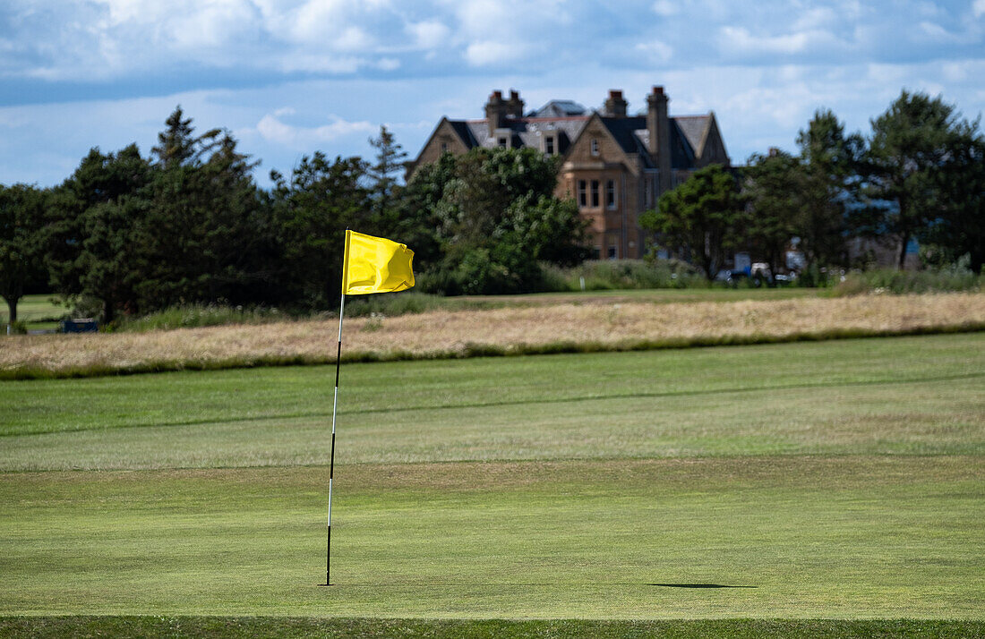 Blick auf das Clubhaus des Winterfield Golf Club, im Vordergrund ein green mit Fahne, Dunbar, East Lothian, Schottland, Vereinigtes Königreich
