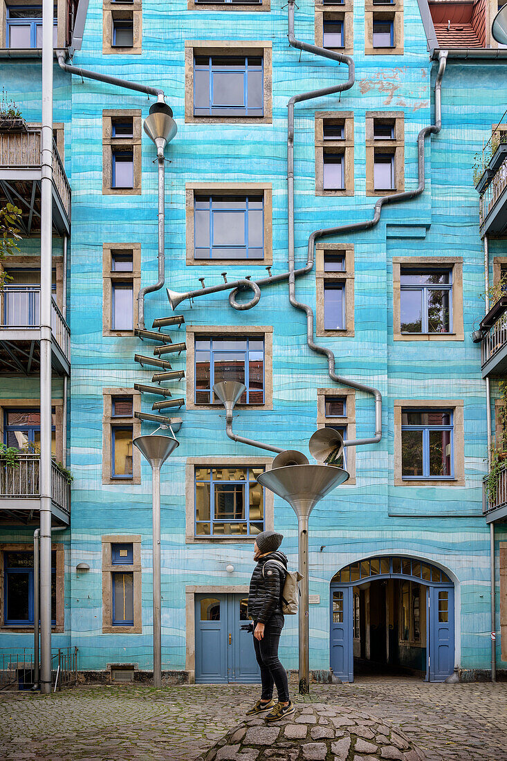 Young woman admires art with funnels in Kunsthofpassage Dresden, Free State of Saxony, Germany, Europe