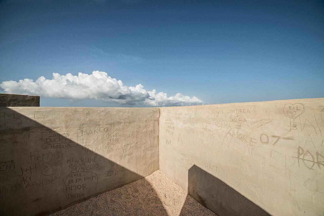 Mauer mit Gravierungen und Schrift, Blick zum Himmel mit Wolken, Algarve, Portugal