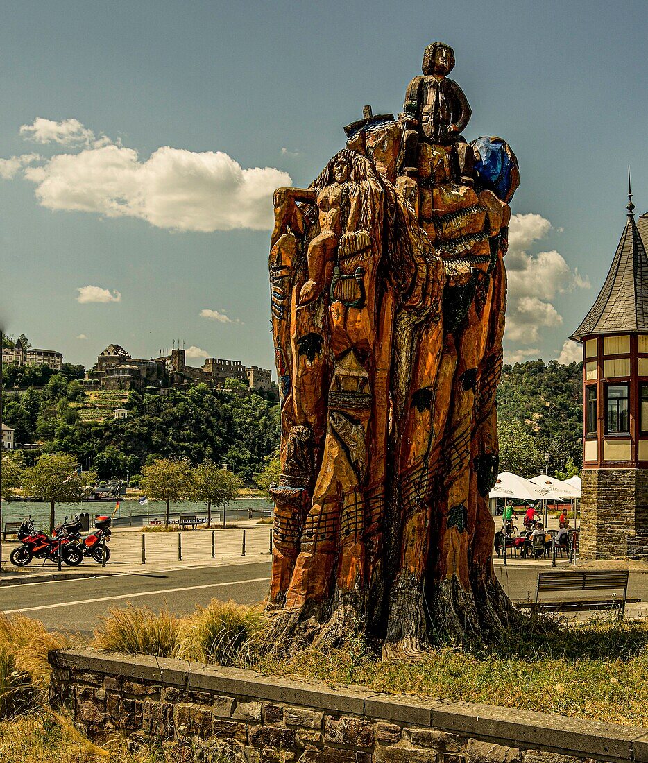 Baumskulptur an der Rheinpromenade mit Loreley-Motiv, im Hintergrund Burg Rheinfels in St. Goar, St. Goarshausen, Oberes Mittelrheintal, Rheinland-Pfalz, Deutschland