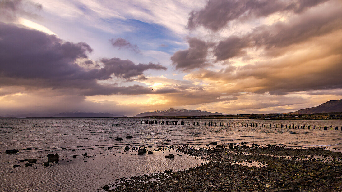 Sonnenuntergang über den Bergen am historischen Steg Muelle Historico am Hafen von Puerto Natales, Chile, Patagonien, Südamerika