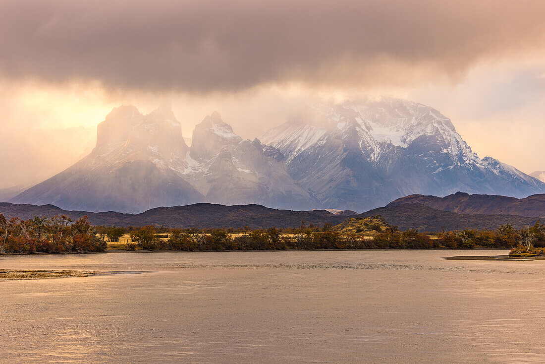 Blick über die Bergkette des Torres del Paine Massivs mit dramatischen Regenwolken im Gegenlicht, Süden von Patagonien, Chile, Südamerika