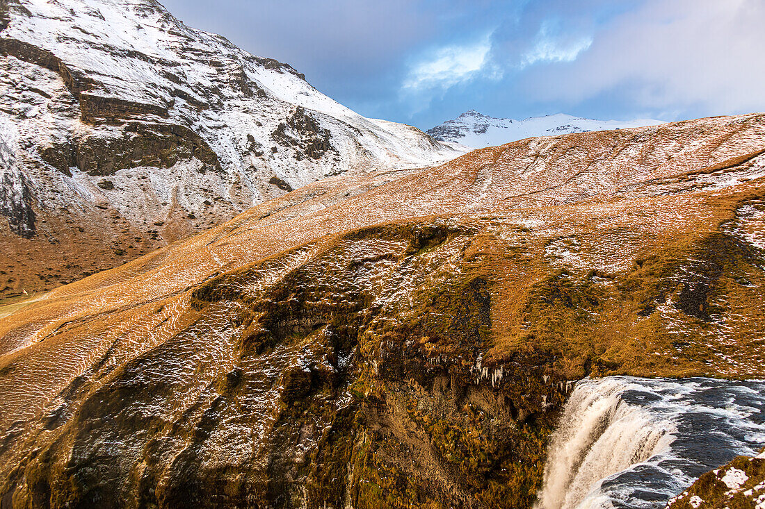 Icy water begins its 60 meter fall over the Skogafoss Waterfall in thje icelandic country side