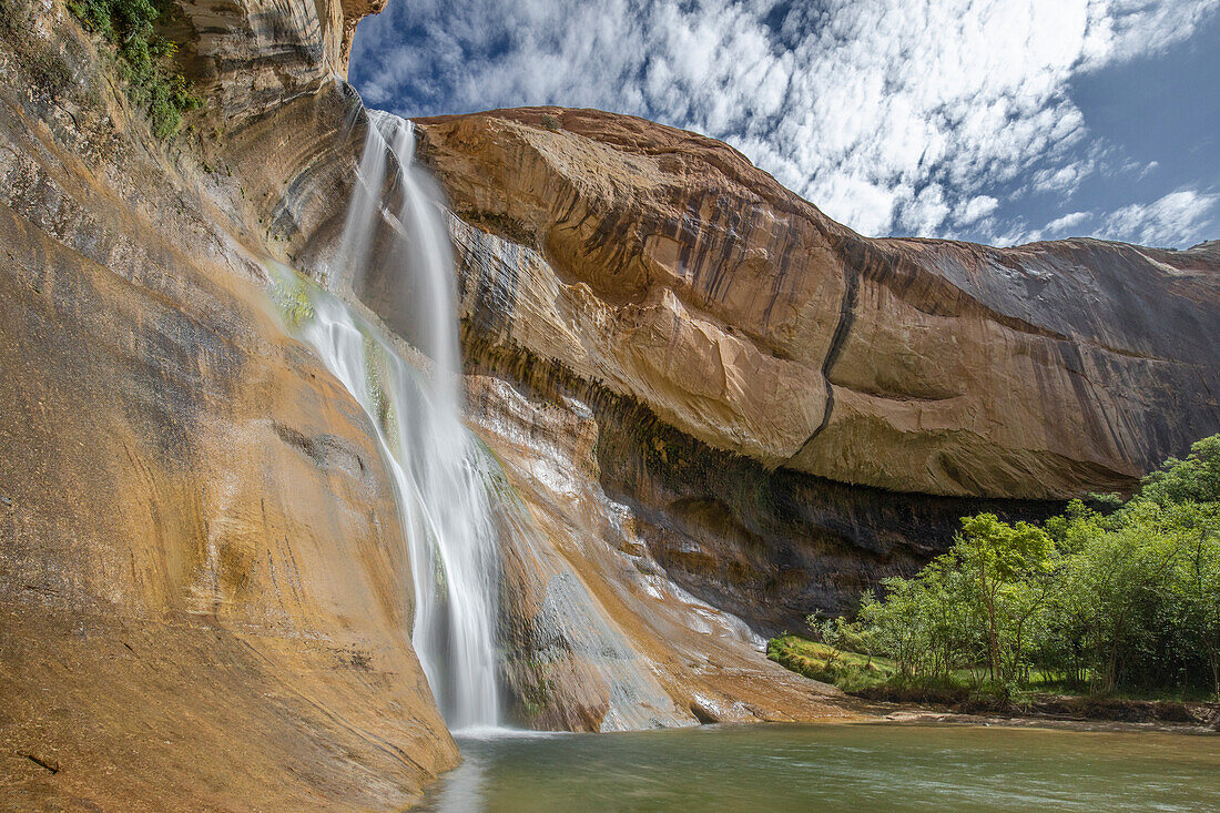 Waterfall and small lake against a blue sky. Lower Calf Creek Falls