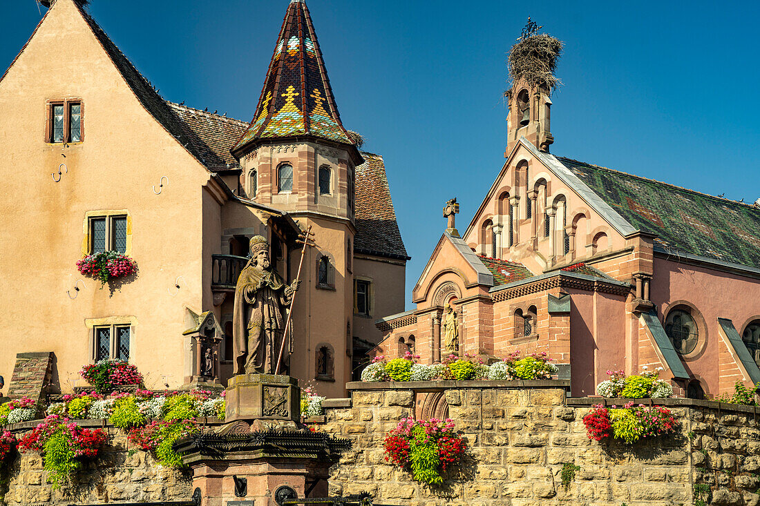 Brunnen Fontaine de Saint-Léon und St.-Leo-Kapelle in Eguisheim, Elsass, Frankreich \n