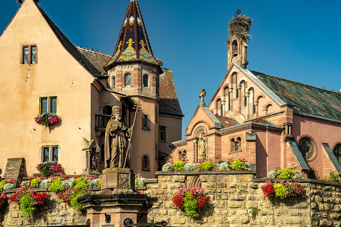 Fountain Fontaine de Saint-Léon and St. Leo Chapel in Eguisheim, Alsace, France