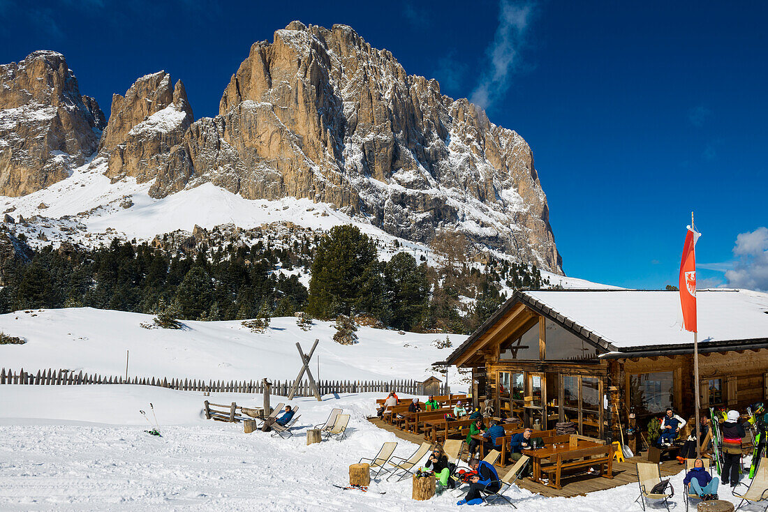 Schneebedeckte Berge, Skifahrer und Skihütte vor Langkofelgruppe, Sella Pass, Grödnertal, Dolomiten, Südtirol, Italien