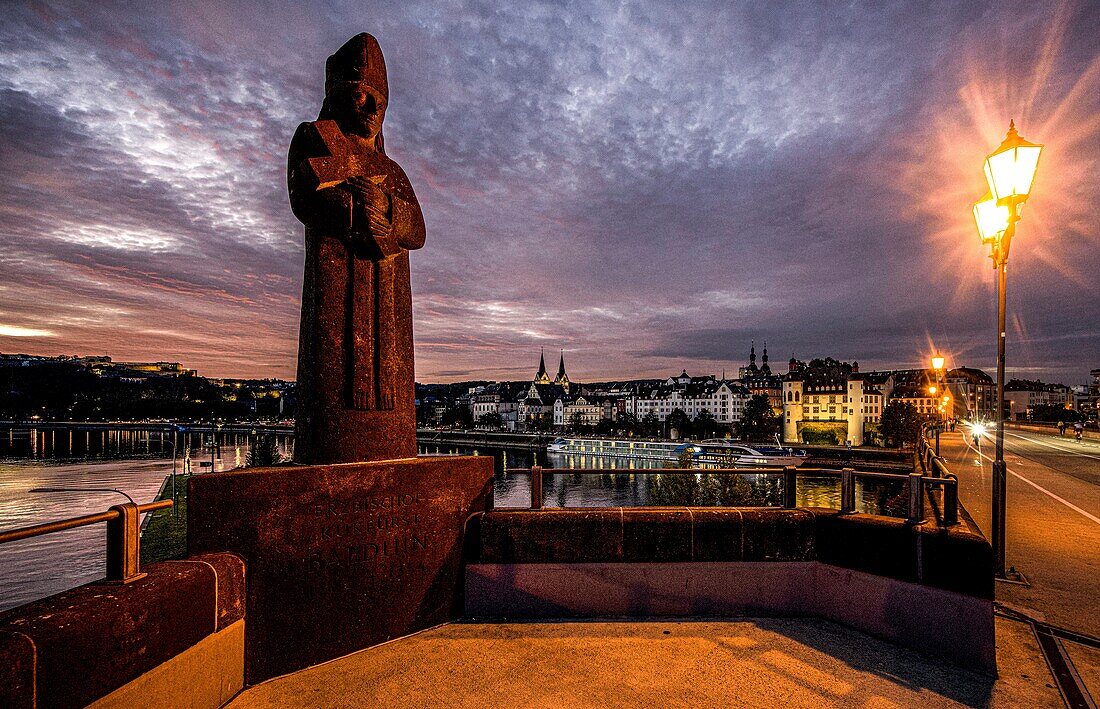 Statue of Elector Balduin on the Balduin Bridge at dawn and lantern light, in the background the old town and the Ehrenbreitstein Fortress, Upper Middle Rhine Valley, Rhineland-Palatinate, Germany