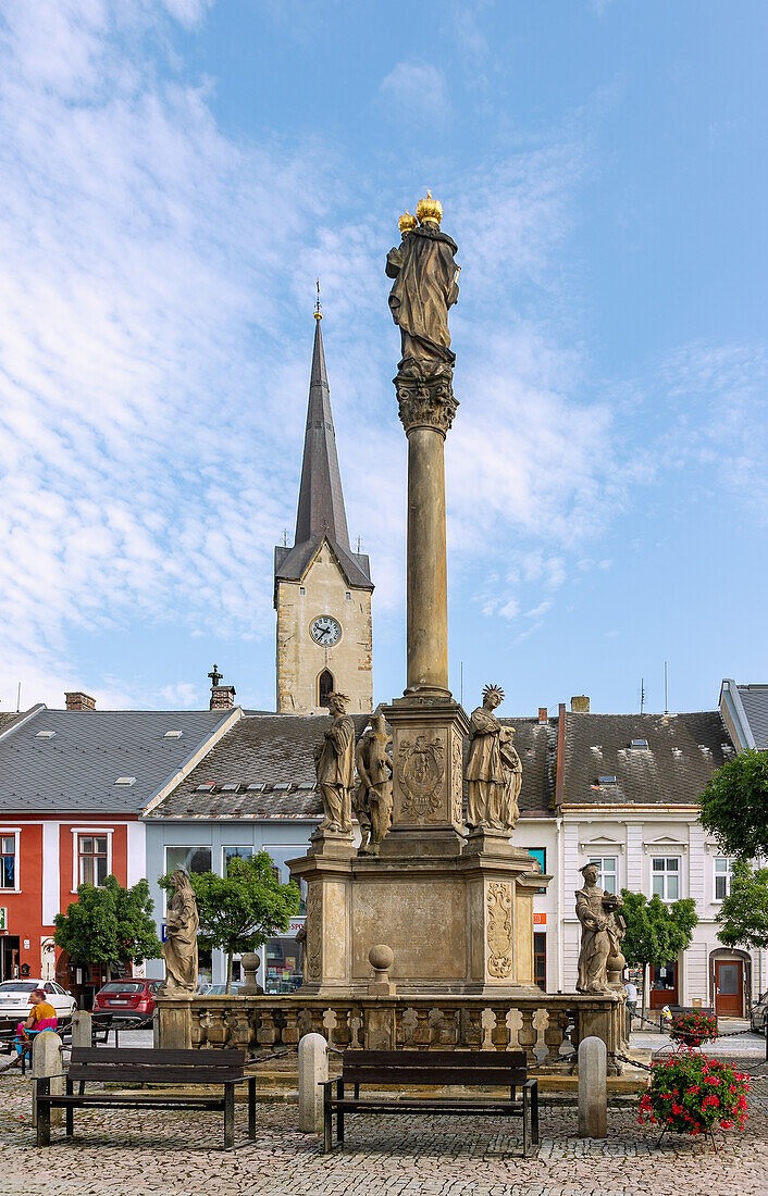Marian column on the market square Náměstí Svobody and church tower of the Kostel svatého Tomáše z Canterbury in Mohelnice in Moravia in the Czech Republic
