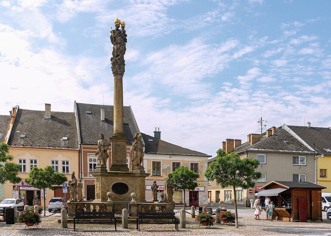 Marian column on the market square Náměstí Svobody and church tower of the Kostel svatého Tomáše z Canterbury in Mohelnice in Moravia in the Czech Republic