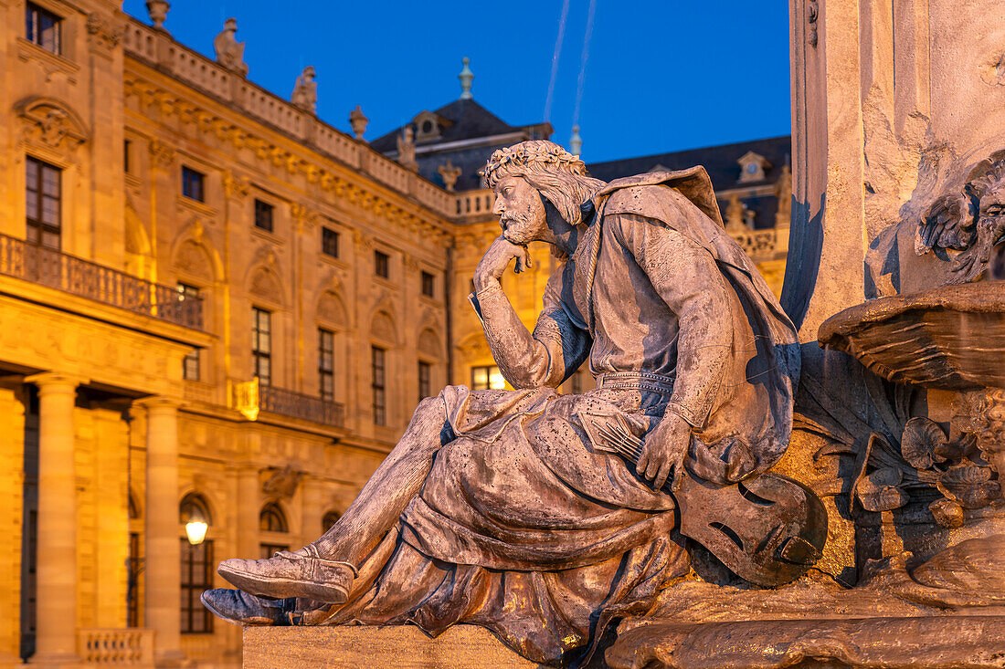 Statue des Dichters Walther von der Vogelweide am Frankoniabrunnen vor der Residenz in der Abenddämmerung, Würzburg, Bayern, Deutschland 
