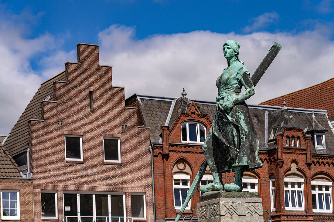 Tine statue of the Asmussen-Woldsen Monument or Tine Fountain in front of the houses of the old town at the market in Husum, Nordfriesland district, Schleswig-Holstein, Germany, Europe