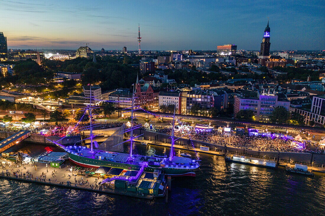 Luftaufnahme von Menschenmassen entlang der Elbe während der Hamburg Cruise Days 2023 in der Abenddämmerung, Hamburg, Deutschland