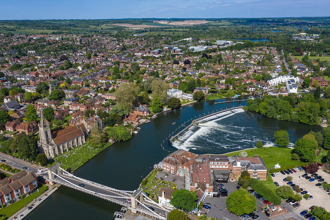 Aerial view of town with All Saints Church, Marlow Suspension Bridge and weir along River Thames, Marlow, Buckinghamshire, England, United Kingdom