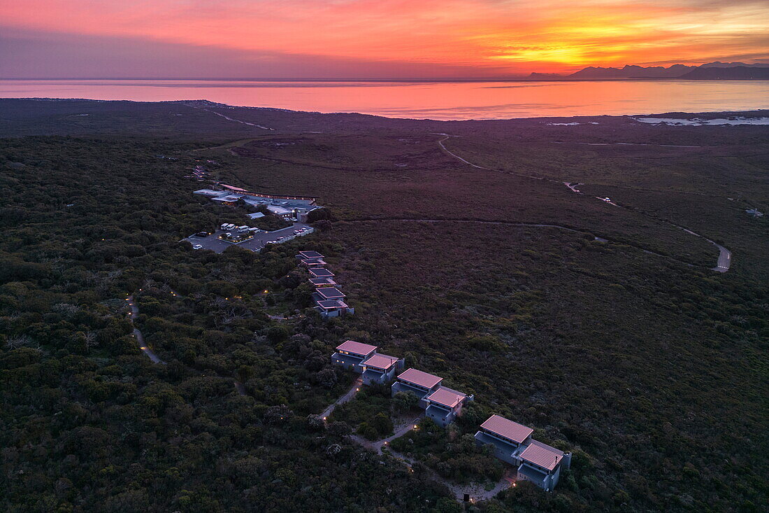 Luftaufnahme der Forest Lodge mit Blick auf die Walker Bay Nature Reserve bei Sonnenuntergang, Grootbos Private Nature Reserve, Westkap, Südafrika