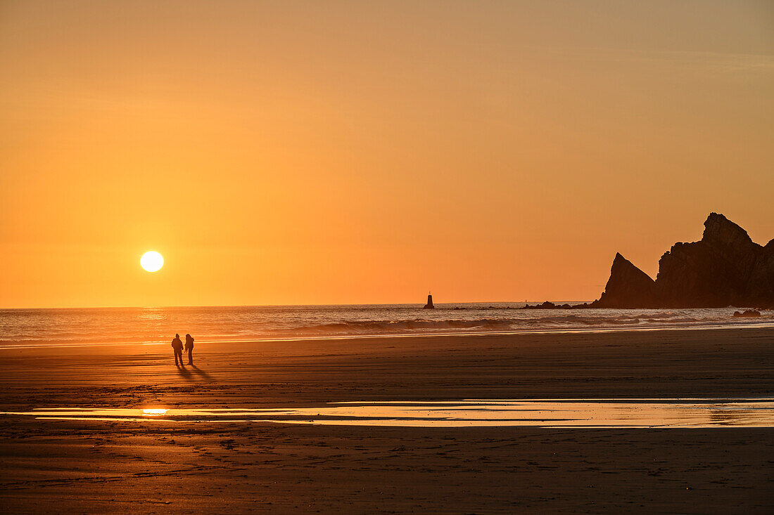 Zwei Personen bei Sonnenuntergang am Strand Plage de Pen Hat, Pointe du Toulinguet im Hintergrund, Camaret-sur-Mer, GR 34, Zöllnerweg, Sentier Côtier, Halbinsel Crozon, Atlantikküste, Bretagne, Frankreich
