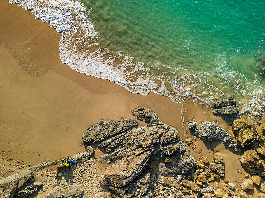 Man and woman hiking sitting on the sandy beach, Cap-Sizun, GR 34, Zöllnerweg, Brittany, France