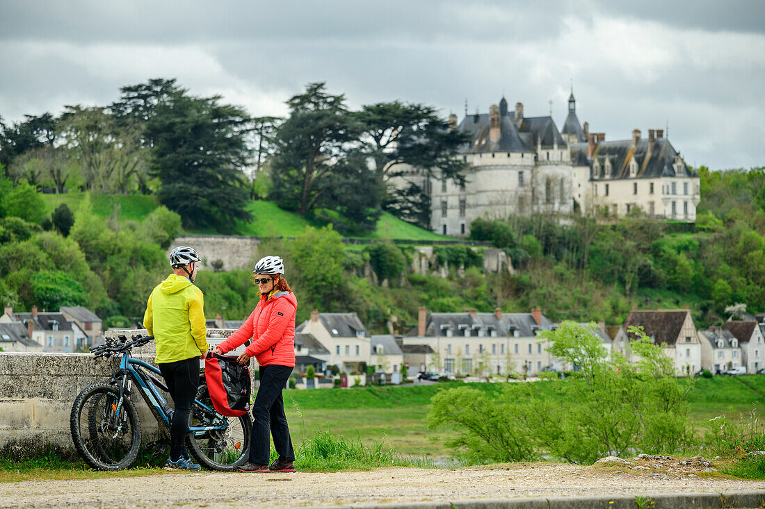 Man and woman cycling taking a break, Château de Chaumont in the background, Loire cycle path, Loire castles, Loire Valley, UNESCO World Heritage Loire Valley, France