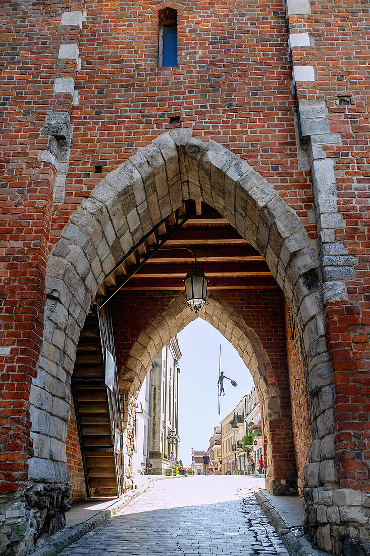 Opatów Gate (Brama Opatowska), sculpture of a bargeman and Opatowska Street in Sandomierz in Podkarpackie Voivodeship of Poland