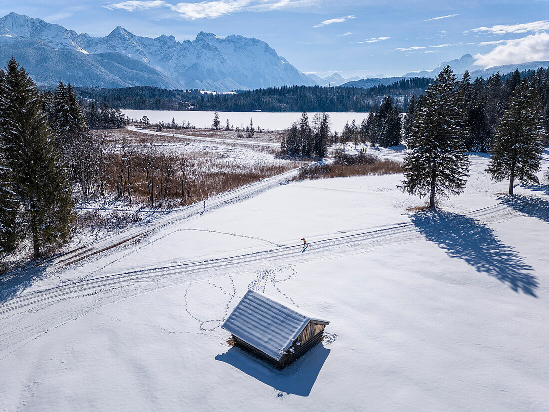 Person beim Langlaufen in der Loipe von Krün, Barmsee und Karwendel im Hintergrund, Werdenfels, Oberbayern, Bayern, Deutschland