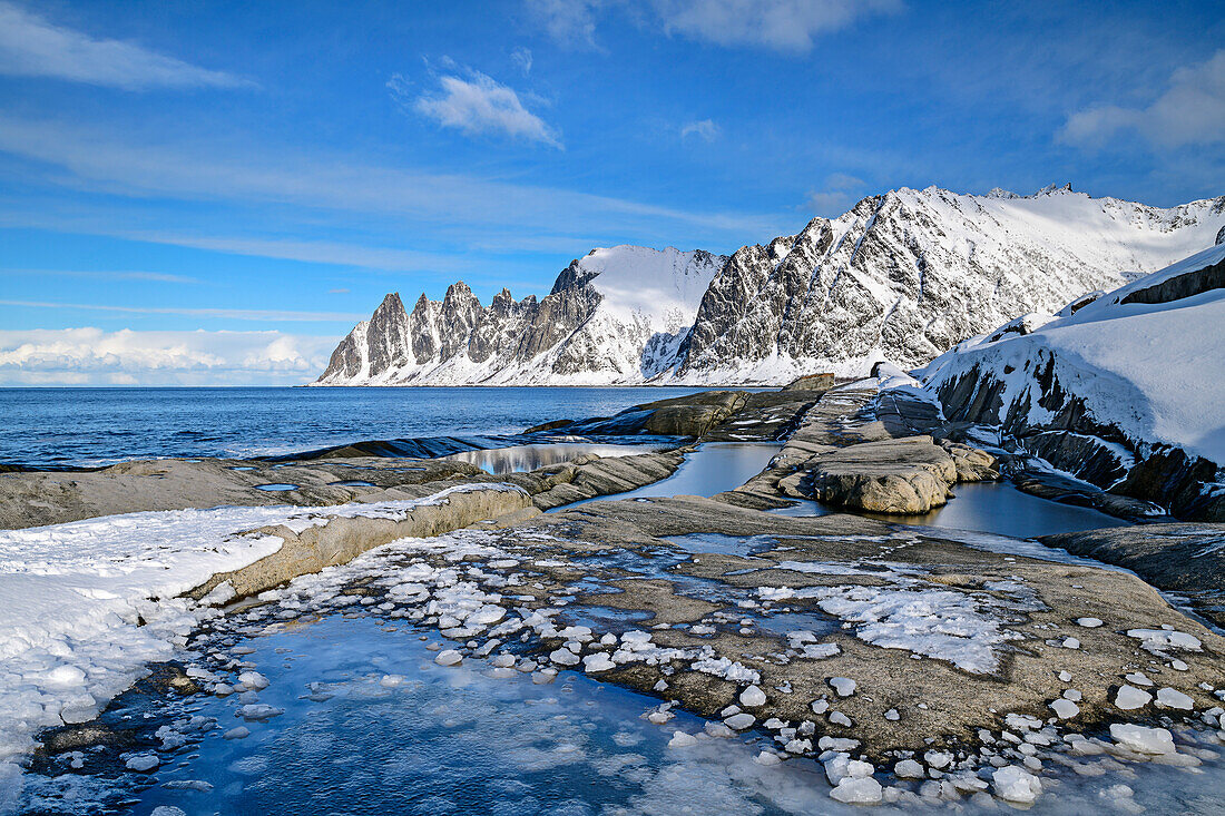 Frozen tide pools on the beach with Devil's Teeth and Ersfjord, Okshornan, Tungeneset, Senja, Troms og Finnmark, Norway