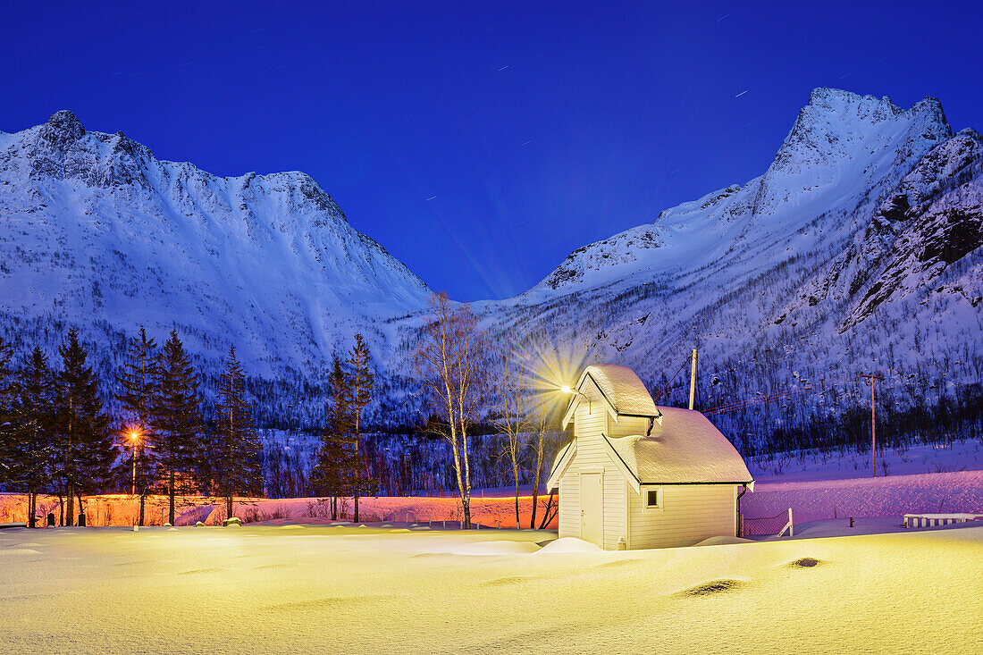 Beleuchtete Kapelle mit Bergen im Hintergrund, Senjahopen, Senja, Troms og Finnmark, Norwegen