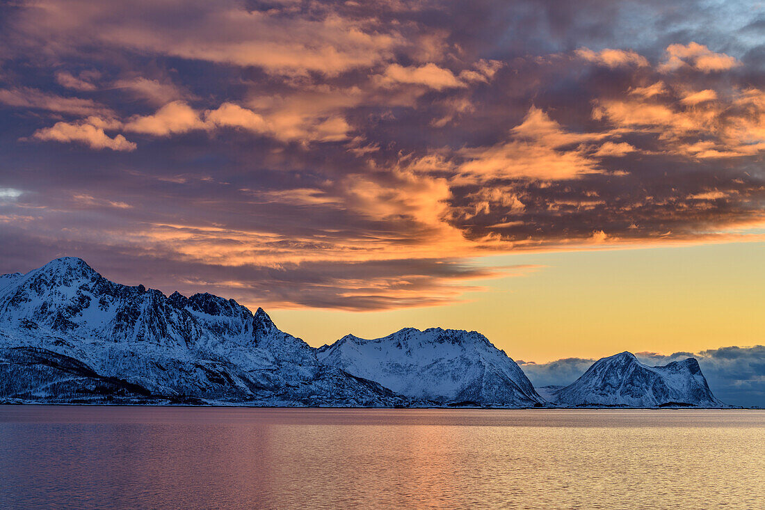 Glühende Wolken im Morgenlicht über dem Nordfjord, Skaland, Senja, Troms og Finnmark, Norwegen