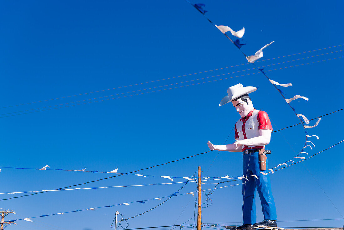 Riesige Cowboy-Statue als Blickfang für ein Autohaus in Gallup, New Mexico, USA