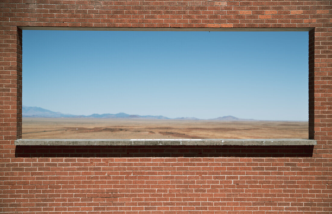 Arizona landscape behind a red brick wall.