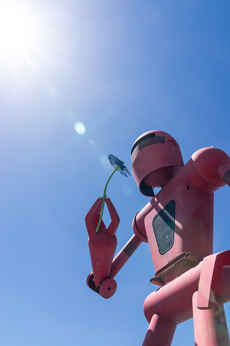 Eine riesige Statue eines Roboters, der eine Metallblume hält, am Eingang von Meow Wolf in Santa Fe, New Mexico.