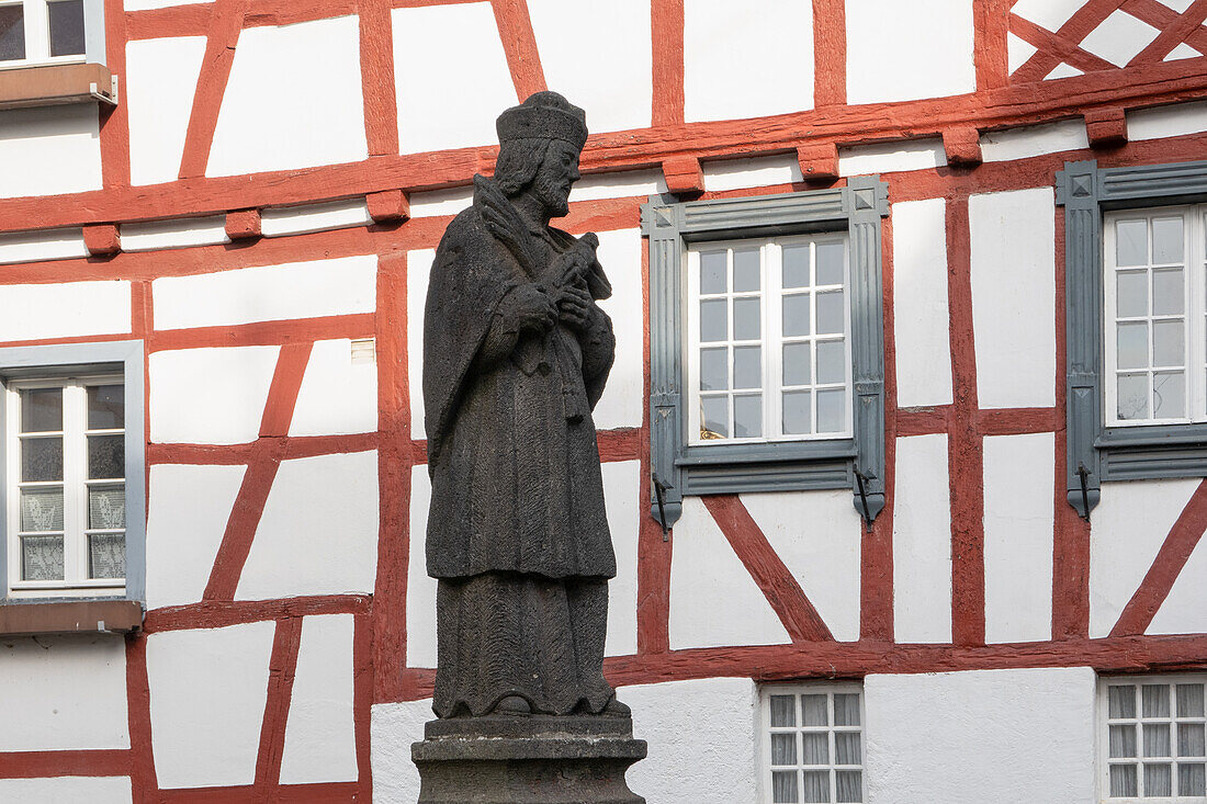 Monreal, bridge saint Nepomuk in front of a half-timbered facade, Rhineland-Palatinate, Germany