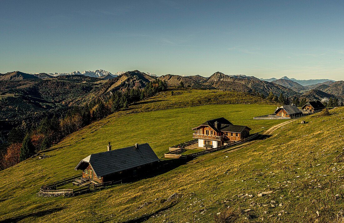 Blick vom Schafberg auf Landhäuser nahe der Schafbergalm, im Hintergrund Almwiesen und die Berge des Salzkammerguts, Österreich