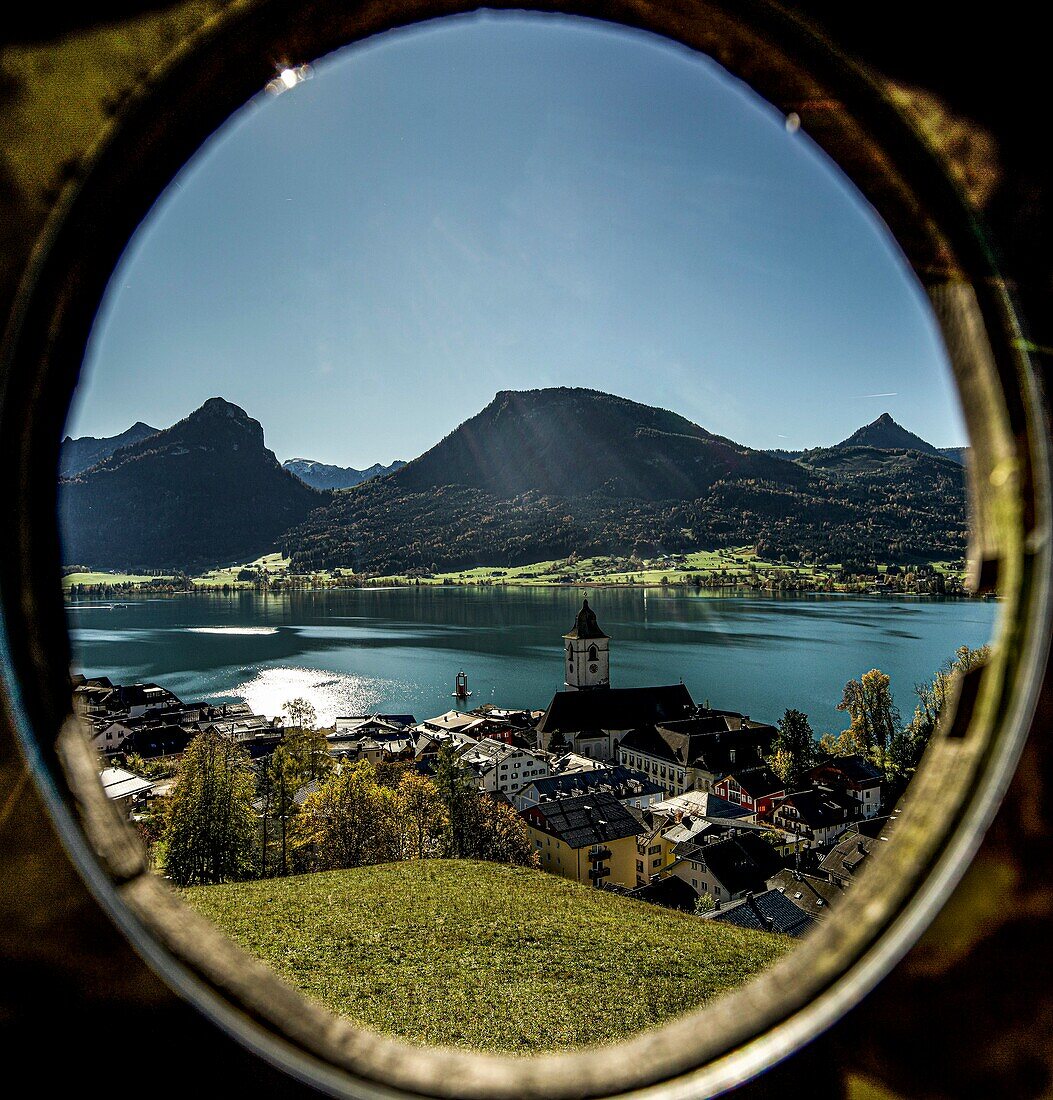 Blick durch einen Rahmen vom Kalvarienberg auf St. Wolfgang, den Wolfgangsee und die Berge des  Salzkammerguts, Österreich
