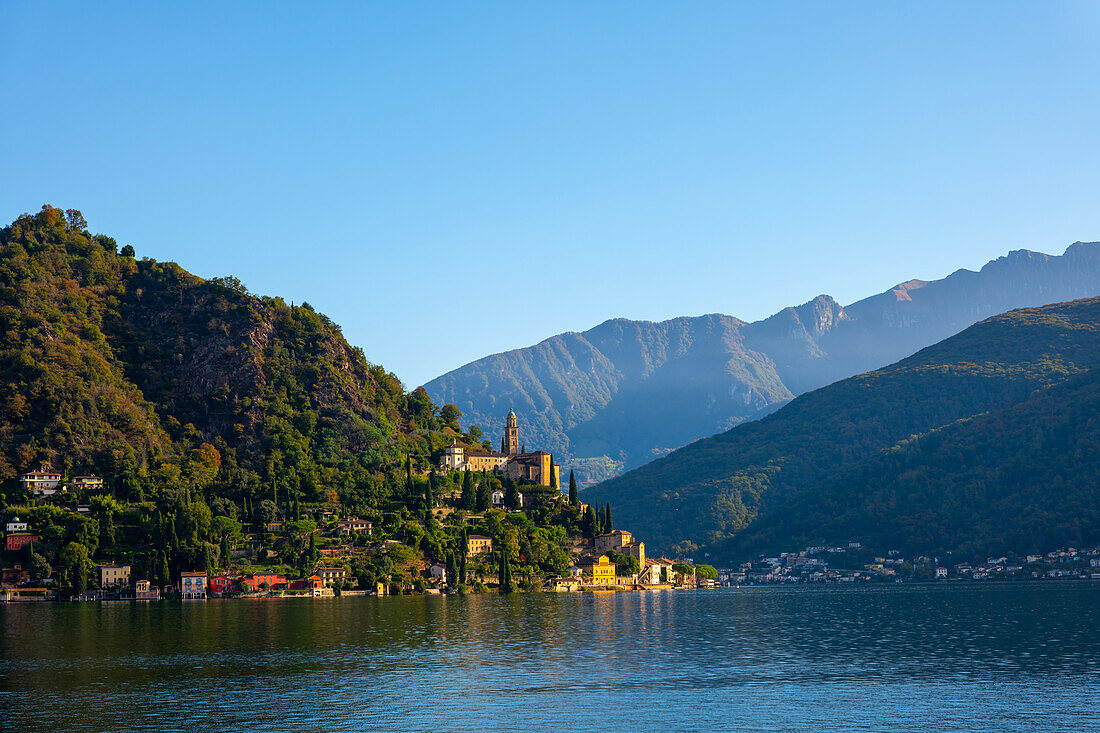 Beautiful Village Morcote witha Chucrh on Lake Lugano and Mountainscape with blue Clear sky in Morcote, Ticino, Switzerland.