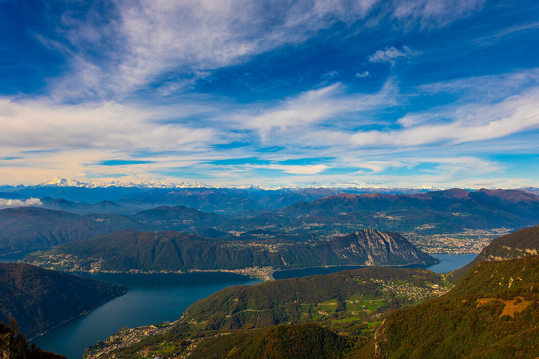 Luftaufnahme über die wunderschöne Berglandschaft mit dem schneebedeckten Monte Rosa und dem Berggipfel Matterhorn sowie dem Luganersee und der Stadt Lugano an einem sonnigen Tag vom Monte Generoso, Tessin, Schweiz.