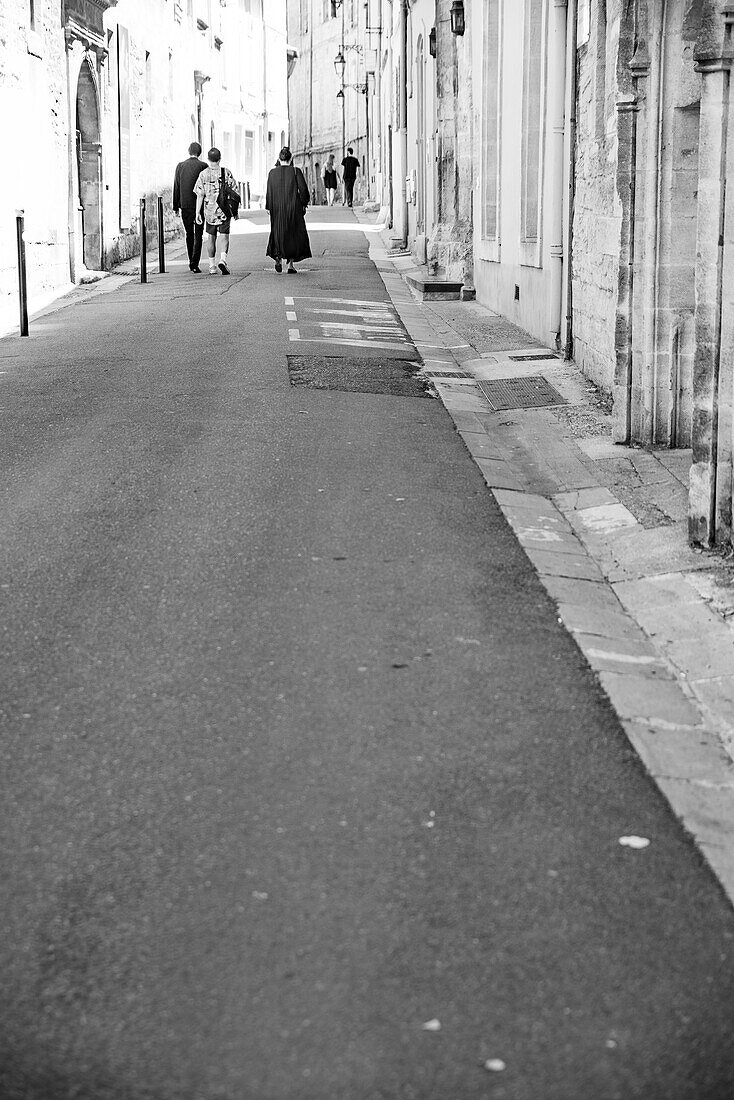 Eine Gruppe von Menschen, die durch die Straßen von Arles, Frankreich, gehen.