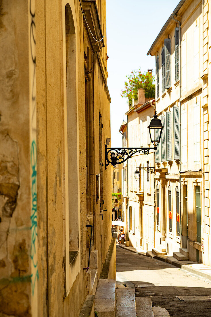 Haus mit Straßenlaterne an einem sonnigen Tag in einer Straße in Arles, Frankreich.