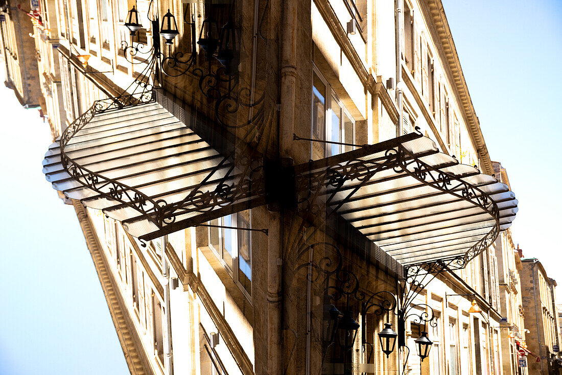 Doppelbelichtung,Vordach aus Glas und Metall vor einem Geschäft in Bordeaux, Frankreich.