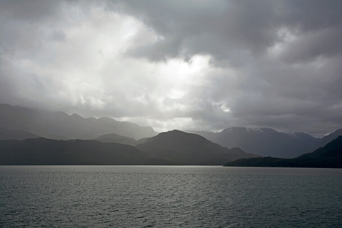 Chile; Southern Chile; Magallanes Region; Mountains of the southern Cordillera Patagonica; on the Navimag ferry through the Patagonian fjords; Angostura Inglesa or English Narrows; low hanging rain clouds; Rain