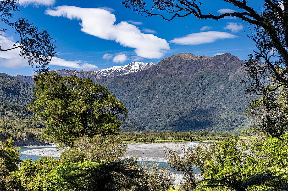 Turquoise waters flow through the Hokitika Gorge amidst lush vegetation and rock formations.