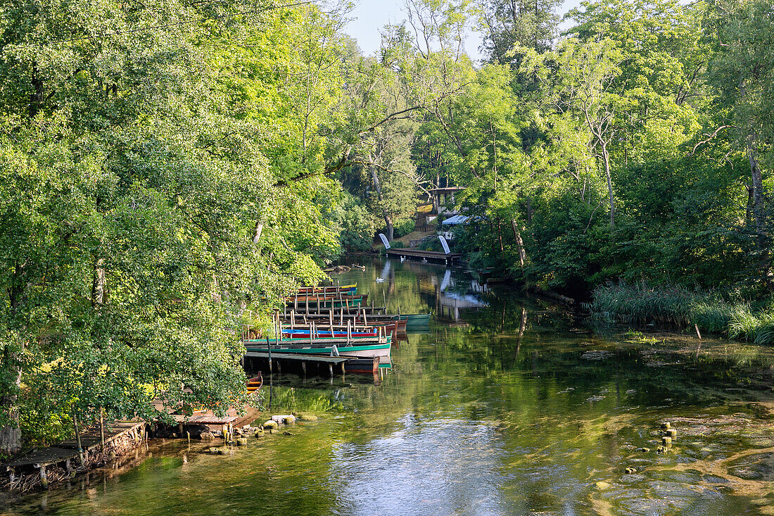 Krutynia River and wooden boats at the pier on the bank in Krutyń in Masuria (Mazury) in Warmińsko-Mazurskie Voivodeship of Poland