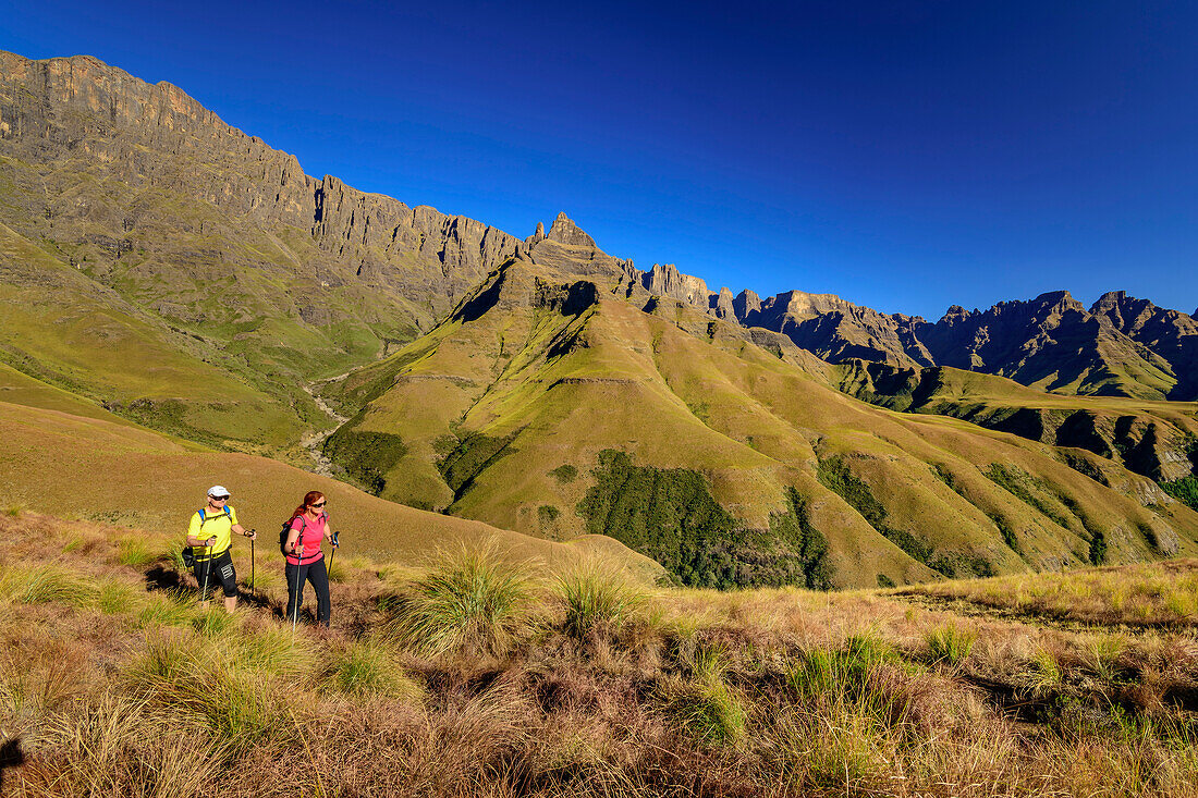 Man and woman hiking up to Organ Pipes Pass, The Pyramid in the background, Didima, Cathedral Peak, Drakensberg, Kwa Zulu Natal, UNESCO World Heritage Site Maloti-Drakensberg, South Africa