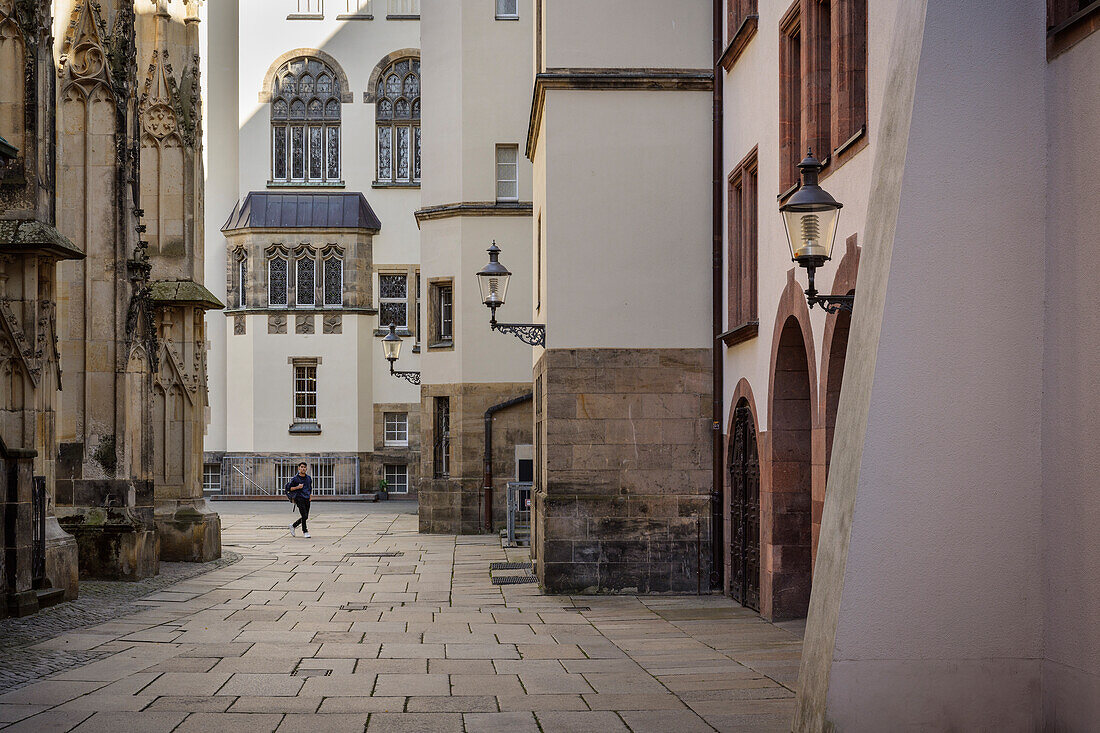 Junger Mann läuft zwischen Altes Rathaus und Sankt Jakobi Kirche, Chemnitz, Sachsen, Deutschland, Europa