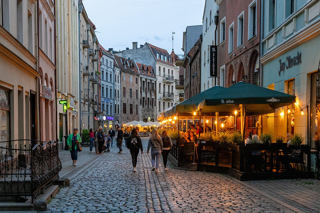 Szczytna Street with restaurant in the evening light in Toruń (Thorn, Torun) in the Kujawsko-Pomorskie Voivodeship of Poland