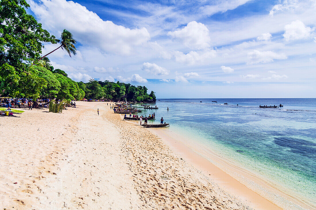Menschen am Strand vor Palmenwald auf den Conflict-Inseln (auch Conflict Atoll), ein Atoll in der Salomonensee, Provinz Milne Bay, Papua-Neuguinea, Melanesien, Südsee