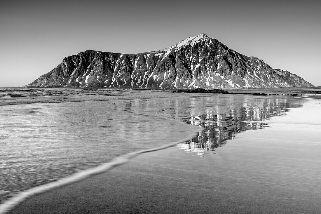 Hustinden reflected in sandy beach, Skagsanden, Lofoten, Nordland, Norway