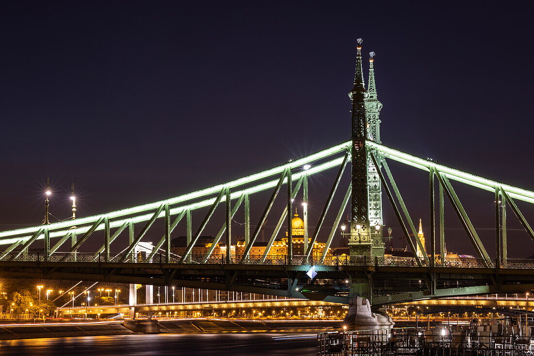 Illuminated Liberty Bridge over the Danube with Buda Castle in the distance at night, Budapest, Pest, Hungary, Europe