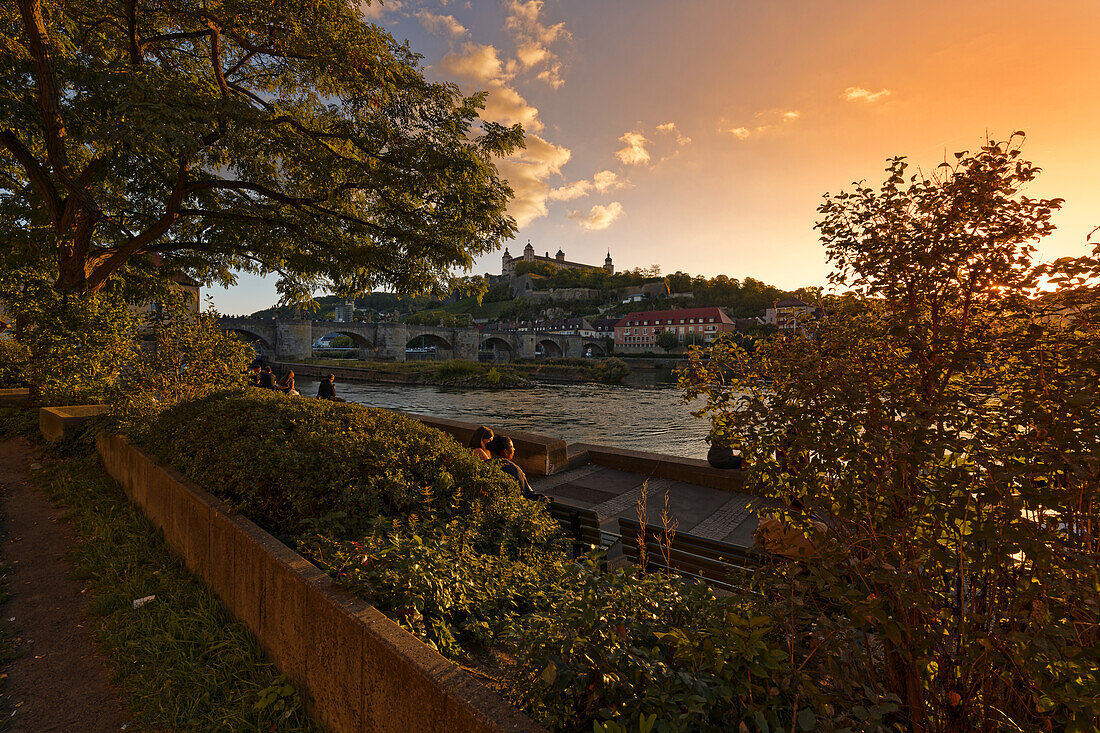 Blick von der Mainpromenade auf die Alte Mainbrücke und die Festung Marienberg in Würzburg zum Sonnenuntergang, Unterfranken, Franken, Bayern, Deutschland                             