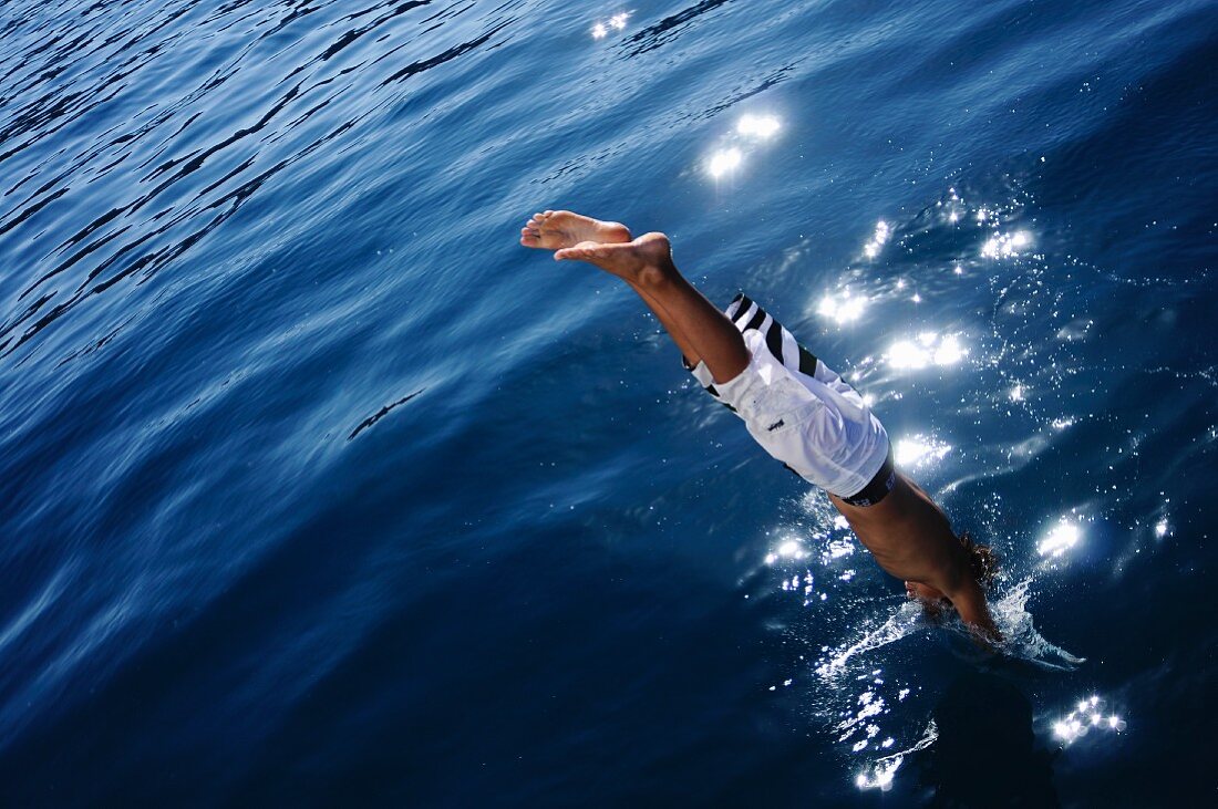 A boy jumping into water