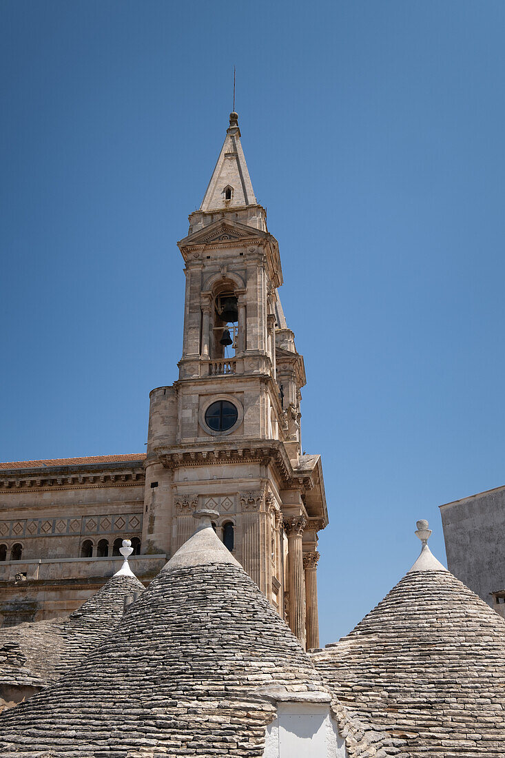 View of the Chiesa dei Santi Medici Cosma e Damiano, in the foreground trulli roofs, Alberobello municipality, Bari province, Apulia region, Italy, Europe